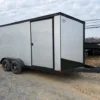 Ding & Dent Covered Wagon 7 x 16 Enclosed Cargo Trailer – All American Edition with dual axles, silver and black exterior, side door, and alloy wheels.