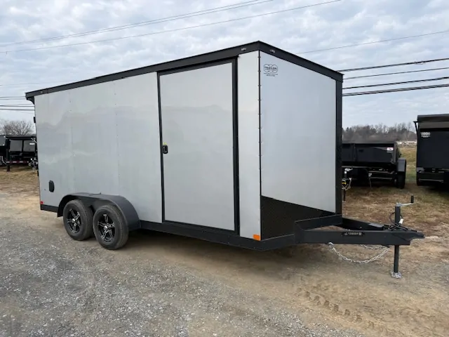 Ding & Dent Covered Wagon 7 x 16 Enclosed Cargo Trailer – All American Edition with dual axles, silver and black exterior, side door, and alloy wheels.